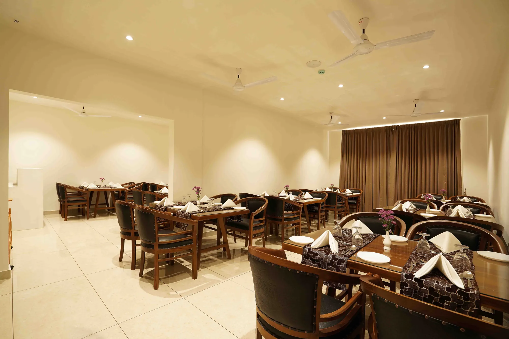 The restaurant by day, with teak chairs and tables laid with folded napkins